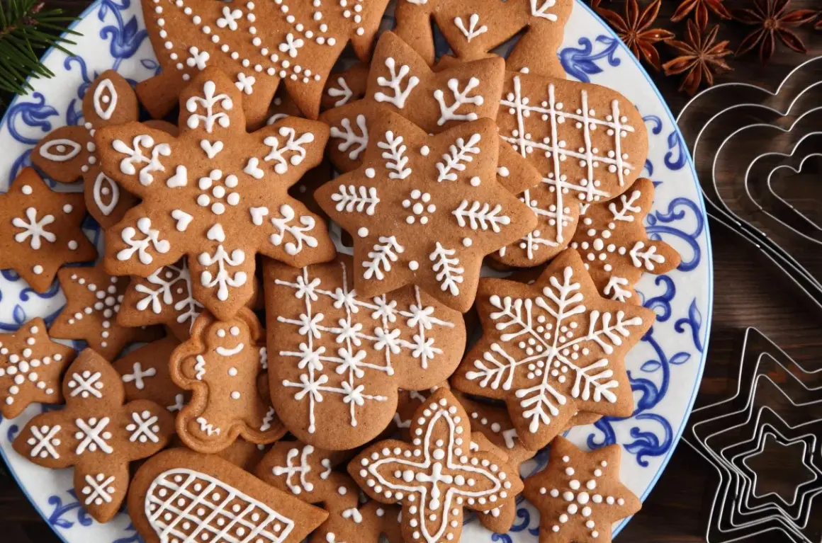 Talerz pełen pierniczków staropolskich (długodojrzewających) ozdobionych białym lukrem. Wśród nich gwiazdki, płatki śniegu i ludziki.