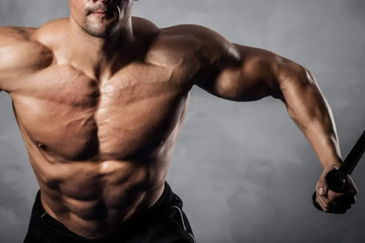 Uomo muscoloso con addominali scolpiti, che si allena con cavi. Ideale per chi cerca recupero e crescita muscolare con aminoacidi dopo allenamento.