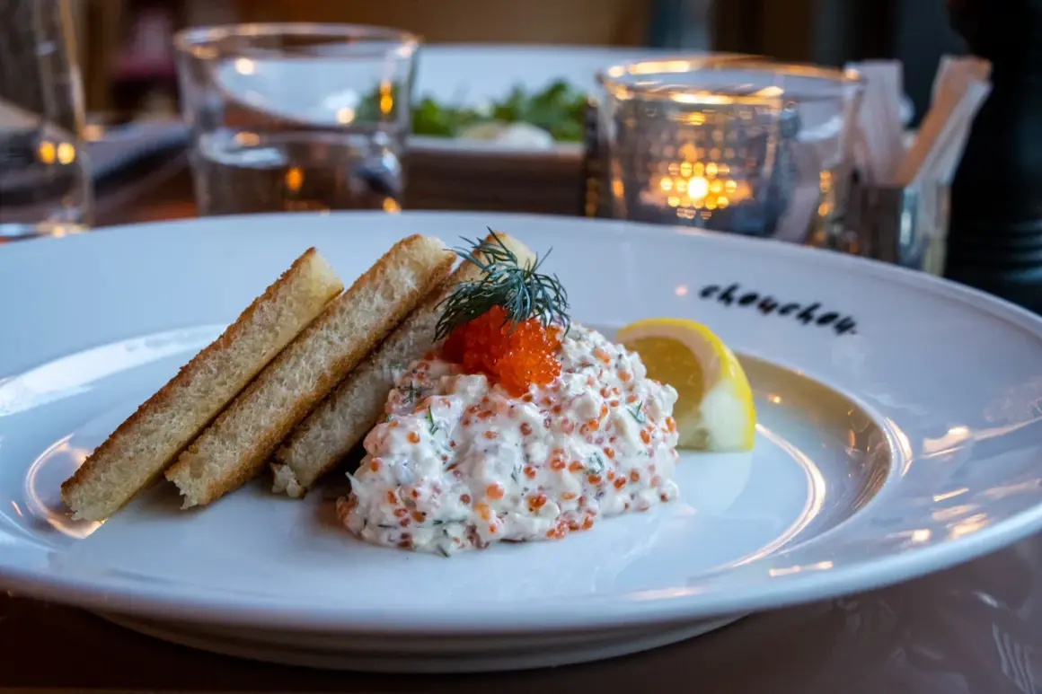 En läcker vegetarisk toast Skagen med rostat bröd, krämig röra med dill och rom, toppad med en dillkvist och citronklyfta.