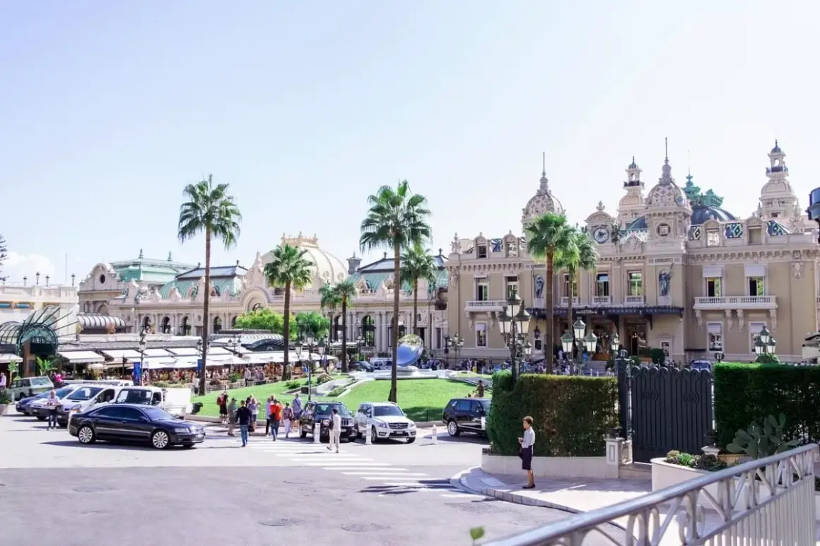 L'iconico Casinò di Montecarlo, un luogo di lusso e divertimento, con palme e auto eleganti. Non una discoteca, ma un simbolo di Montecarlo.
