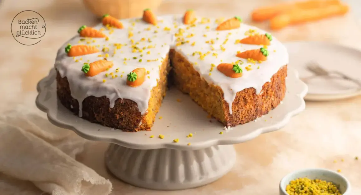 Ein saftiger karottenkuchen mit cremigem frosting, dekoriert mit kleinen Marzipan-Karotten und gehackten Pistazien.