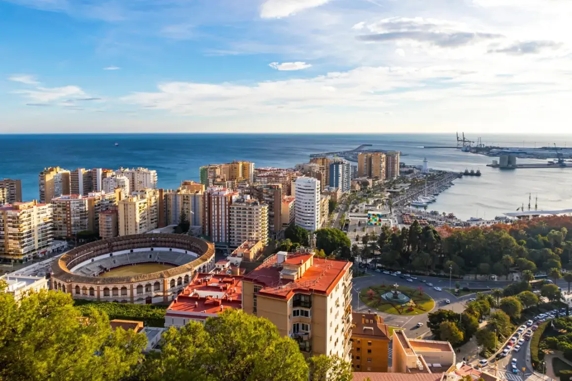 Malaga we wrześniu: słoneczna pogoda, błękitne morze, amfiteatr i port. Miasto tętni życiem pod błękitnym niebem.