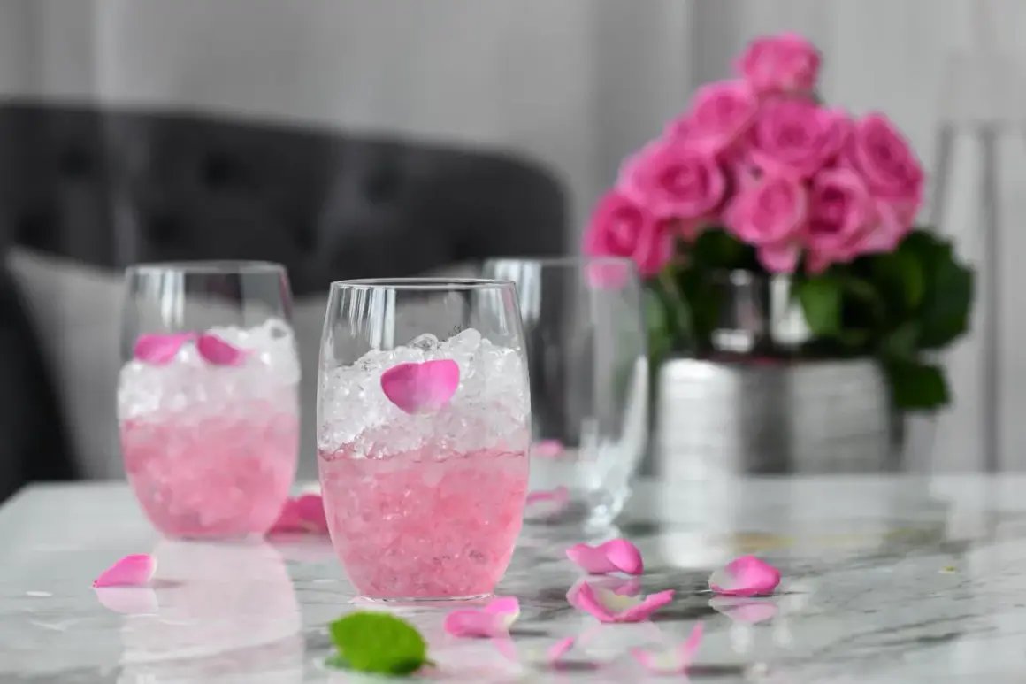 Różowe drinki z winem, lodem i płatkami róż. Eleganckie, orzeźwiające napoje na letnie popołudnie.