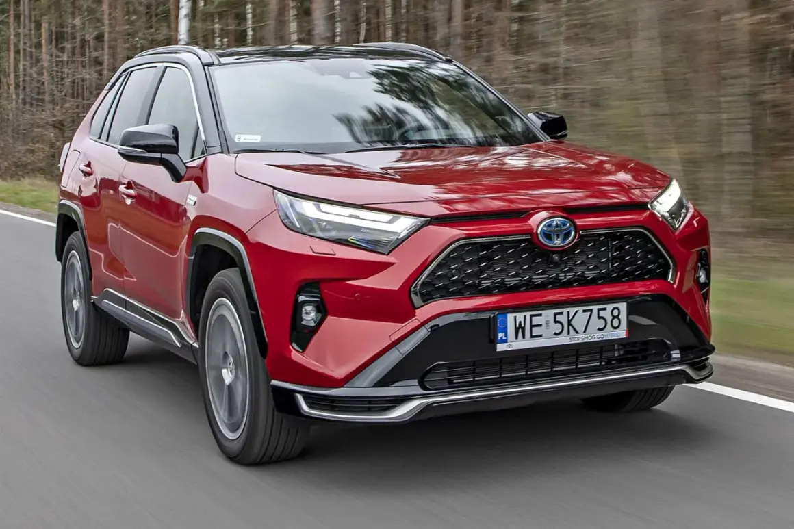 Czerwona Toyota RAV4 Hybrid w ruchu. Sprawdź aktualny toyota rav4 cennik i odkryj możliwości tego SUV-a.