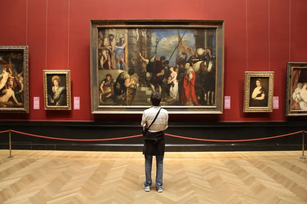 A person contemplates a large painting in a museum, perhaps inspired by the best art history graduate programs.