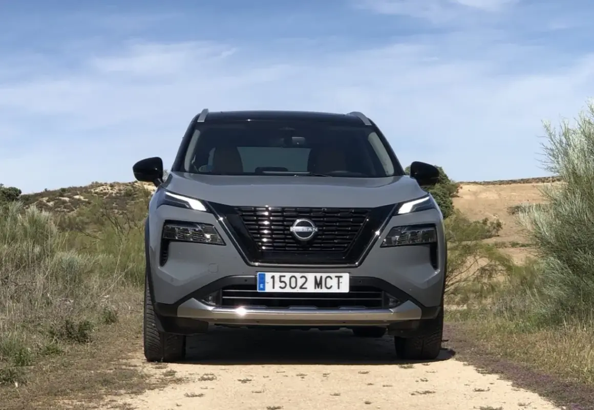 Grå Nissan X-Trail står på en grusväg. En potentiell nissan x-trail problem kan vara att den fastnar i terrängen.