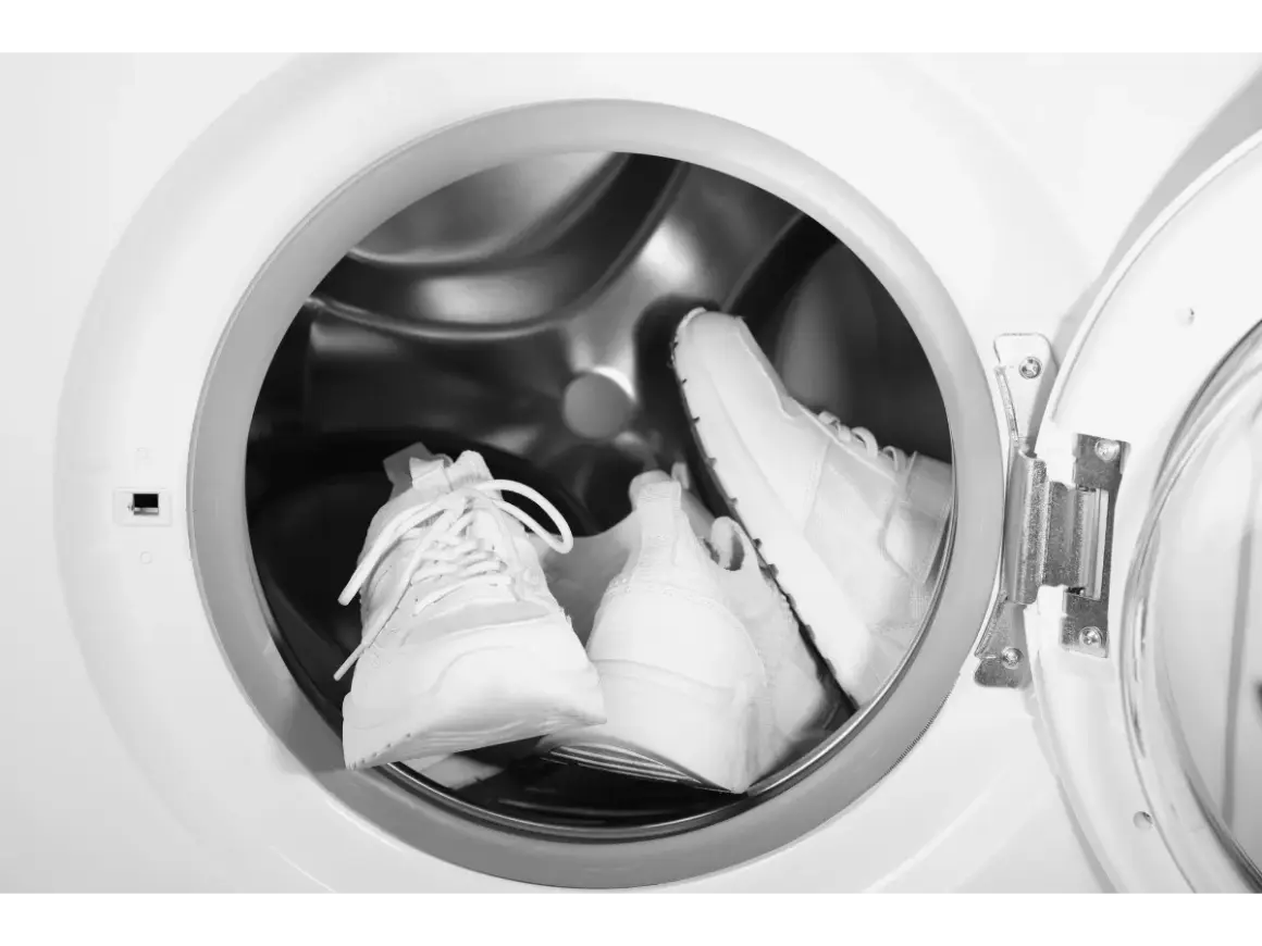 Deux baskets blanches sont prêtes pour leur entretien dans un lave-linge.
