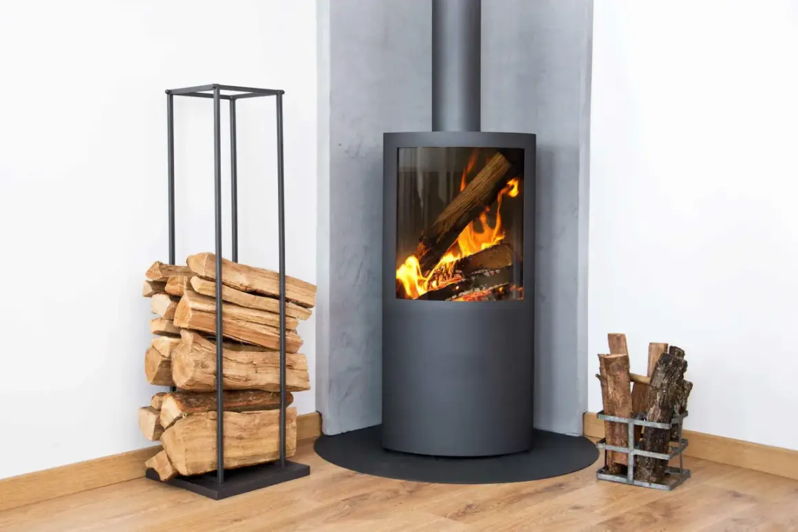 Moderner Kamin mit brennendem Holz. Links Holzstapel, rechts kleiner Holzkorb. Überlegungen zu kamin austauschen kosten sind hier fehl am Platz.