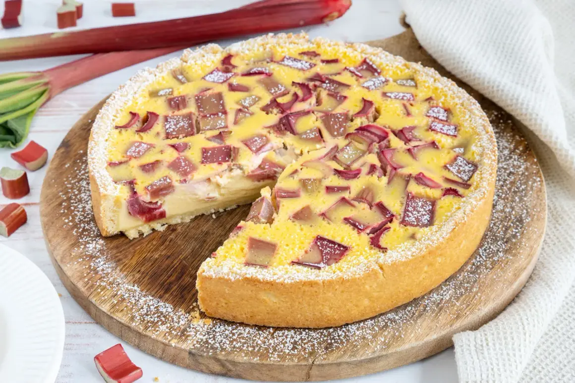 Ein köstlicher Rhabarberkuchen mit Schmand, bestreut mit Puderzucker. Frischer Rhabarber und eine cremige Füllung machen diesen Kuchen zum Genuss.
