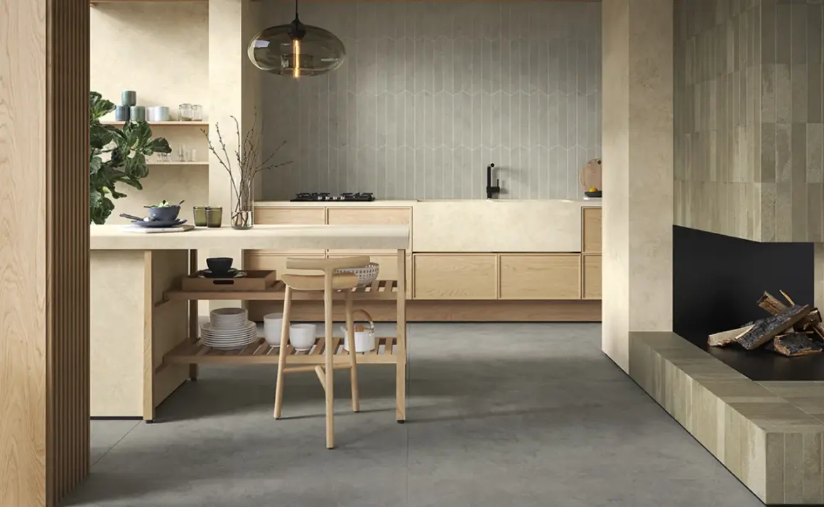 Cucina moderna con finiture in pittura colore sabbia del deserto, isola centrale in legno e camino.