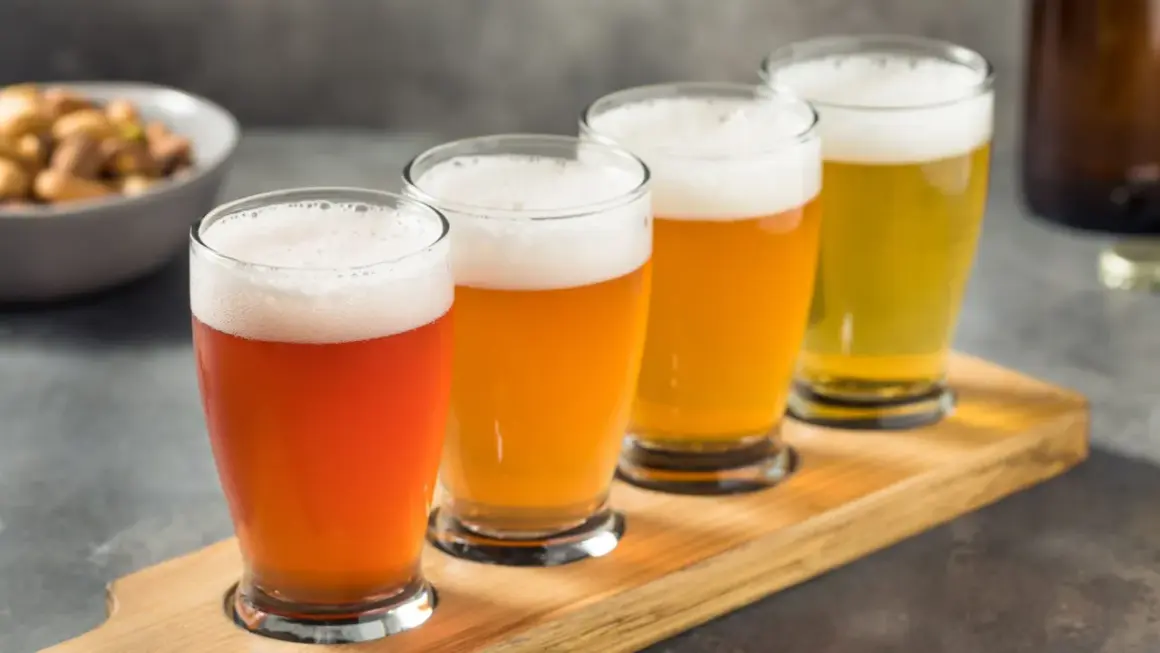 Quattro bicchieri di birra di diversi colori, un assaggio che racconta la storia della birra.