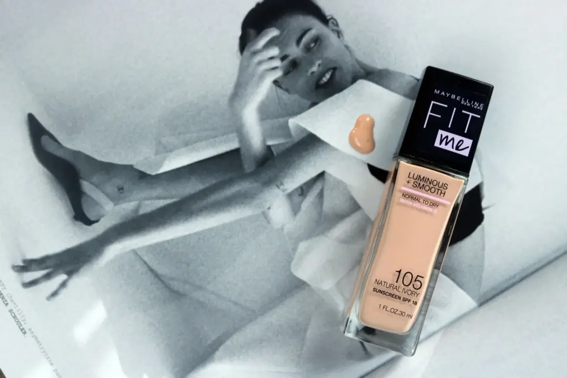 Maybelline Fit Me podkład rozświetlający w odcieniu 105 Natural Ivory na tle czarno-białej sesji zdjęciowej.