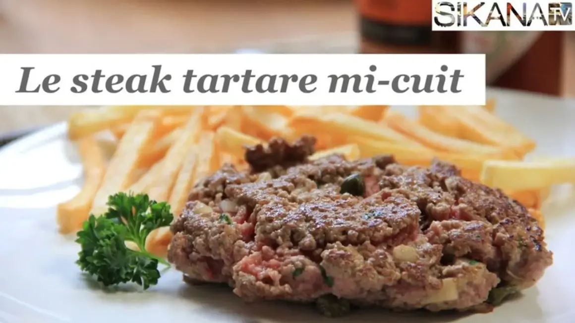 Un steak tartare mi-cuit, savoureux et juteux, servi avec des frites croustillantes et une touche de persil frais. Un délice pour les amateurs de viande.