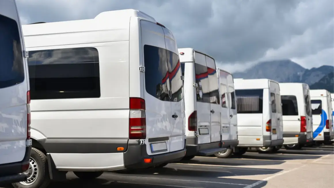 Rząd białych busów gotowych do wyjazdu z Zakopanego na Palenicę Białczańską.