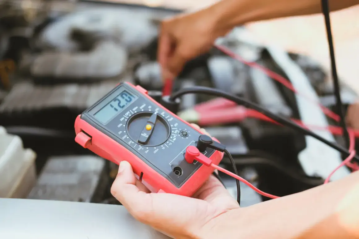 Diagnostic d'une électrovanne turbo défectueuse symptôme : un mécanicien utilise un multimètre pour tester le circuit.