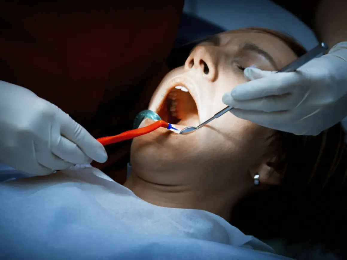 Dentysta bada jamę ustną pacjentki. Czy antybiotyk pomoże na ropień zęba?