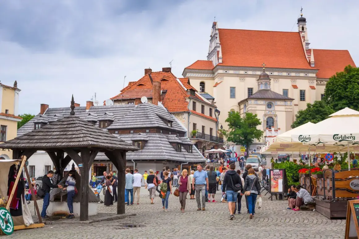 Rynek w Kazimierzu Dolnym, idealne miejsce, gdzie na wakacje w Polsce. Ludzie spacerują, podziwiając zabytkową architekturę i atmosferę.