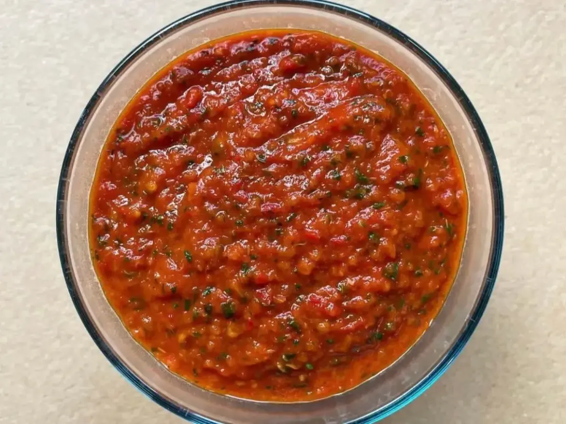 Bagnetto rosso piemontese in una ciotola di vetro, un condimento saporito e piccante, perfetto per accompagnare bolliti e carni.