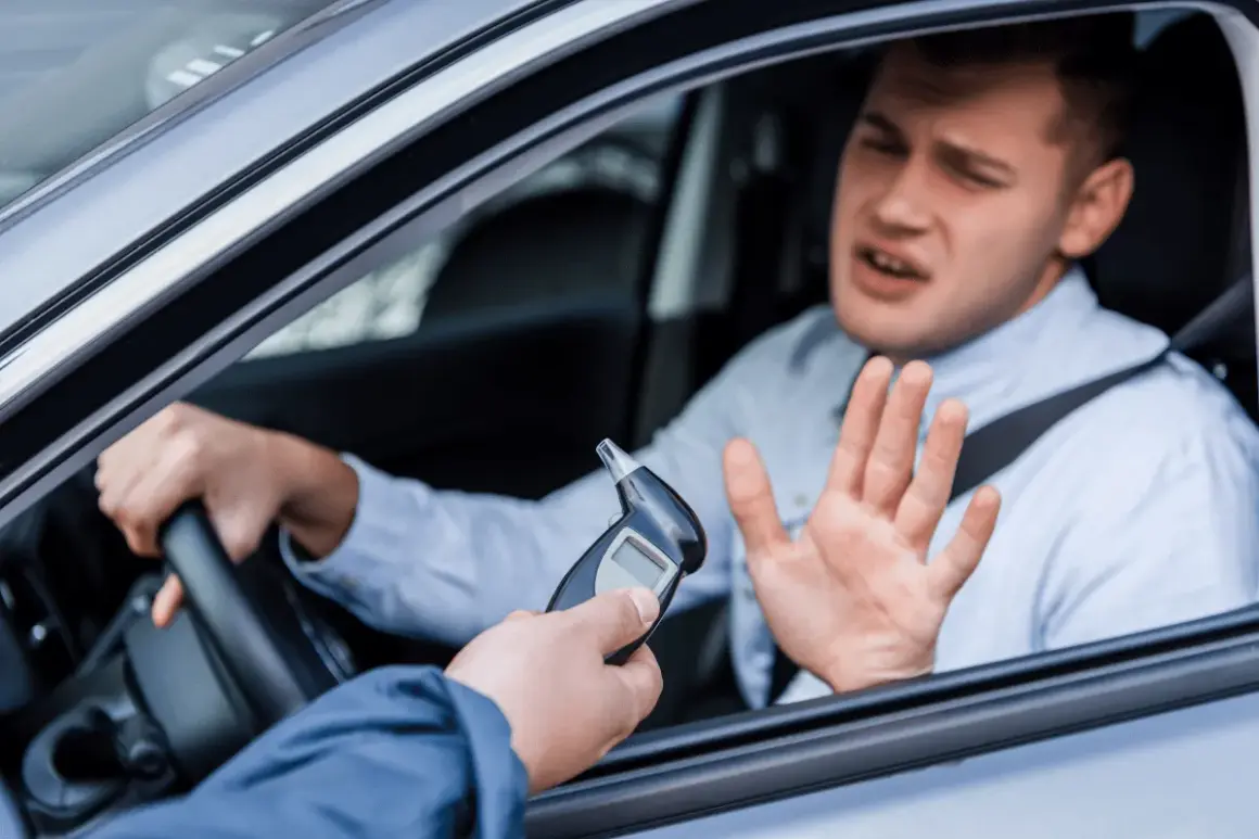 Mann im Auto wehrt sich gegen Alkoholtest. 1,1 Promille Strafe droht.