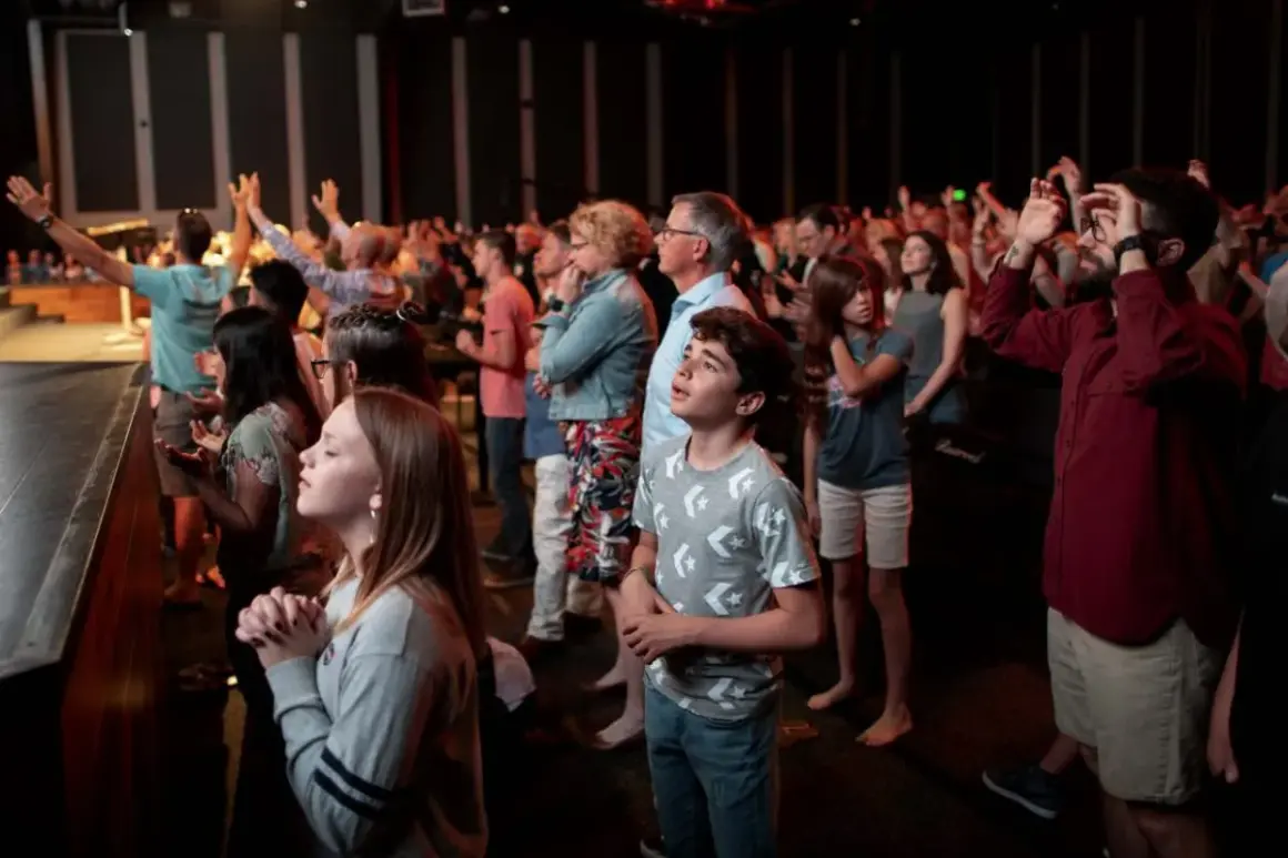Menschen beten und singen in der Bethel Church. Eine Warnung vor übermäßiger Begeisterung könnte hier angebracht sein.