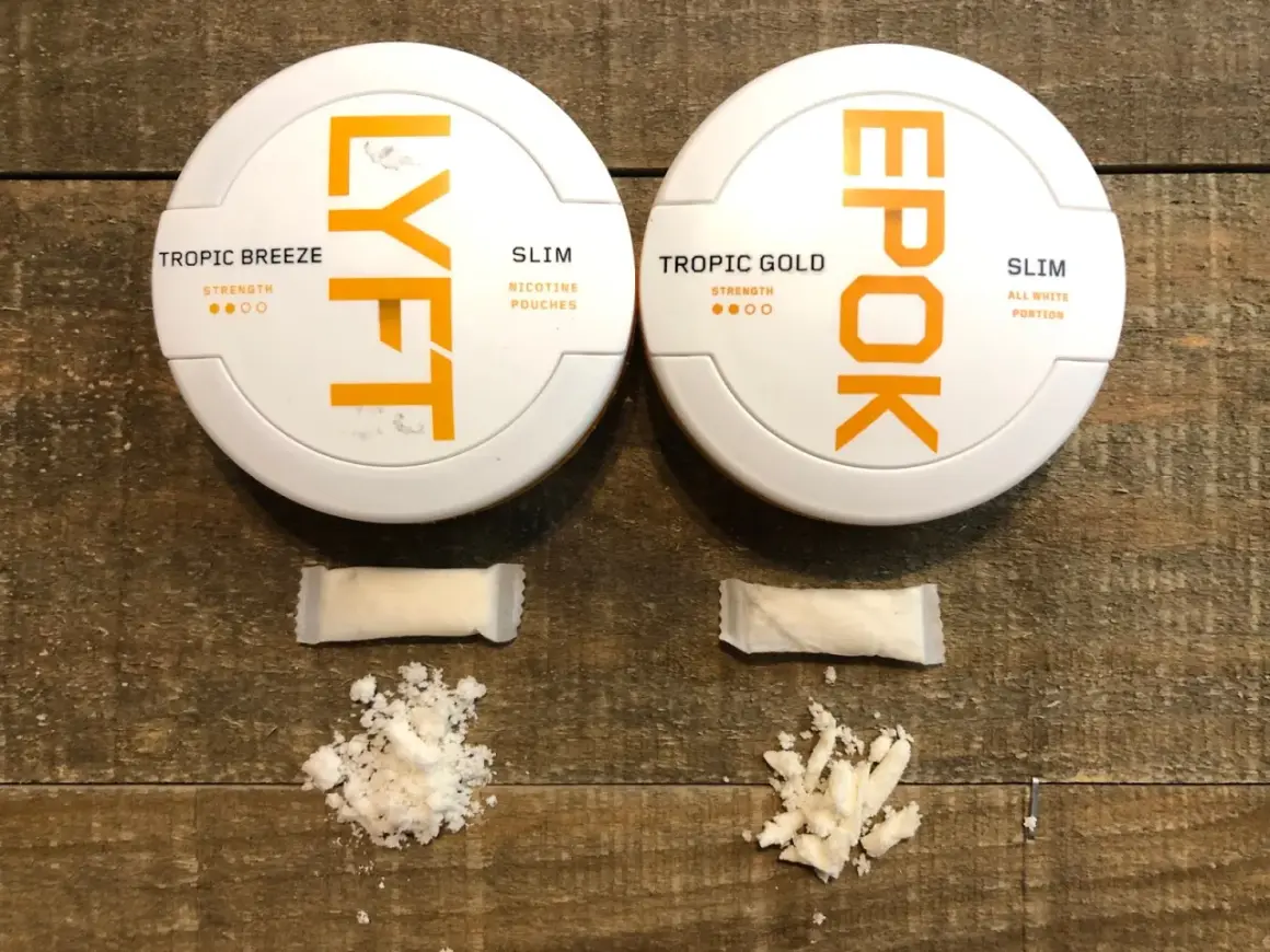 Två dosor snus, LYFT och EPOK, med tillhörande portionspåsar och lössnus. LYFT hette tidigare EPOK.