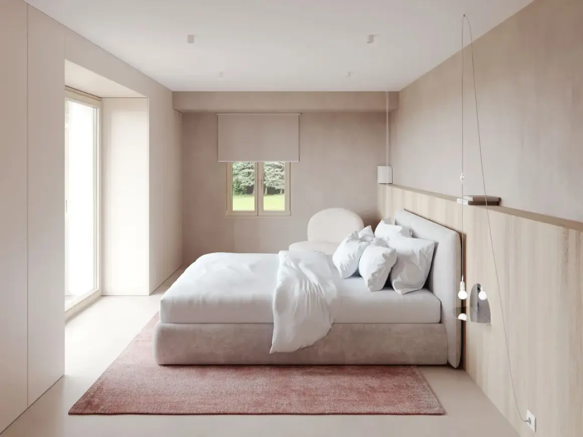 Chambre moderne épurée avec lit blanc, tapis rose et fenêtre donnant sur un jardin.
