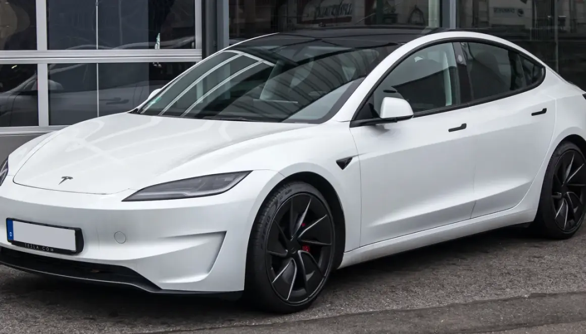 Tesla Model 3 blanco con techo negro. Su diseño aerodinámico sugiere una gran autonomía, optimizando la capacidad de la batería para viajes largos.