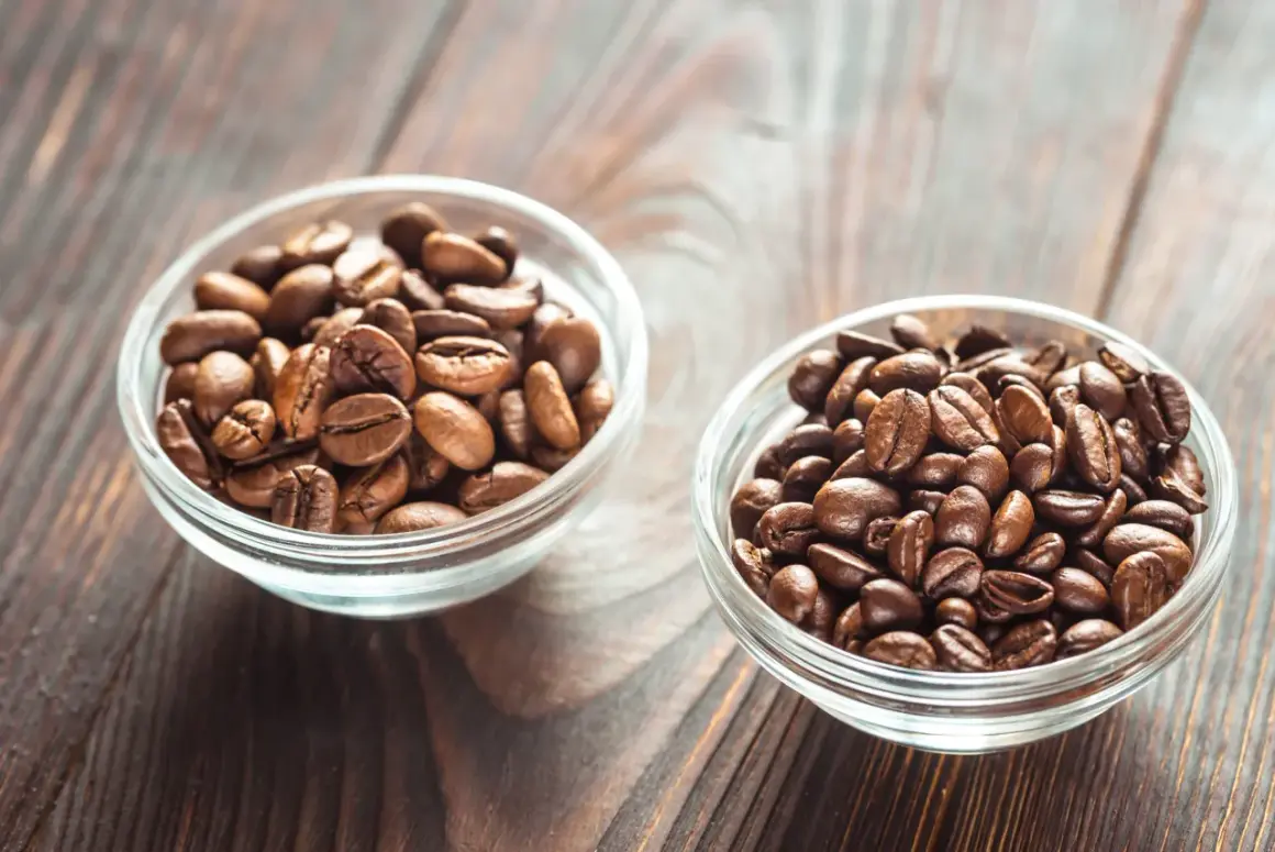 Due ciotole di vetro piene di chicchi di caffè tostati, una con chicchi più chiari, l'altra più scuri, per scegliere tra arabica o robusta.