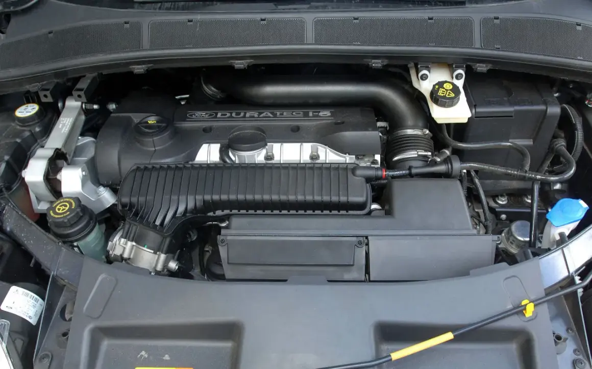 Silnik Duratec 1.5 w Fordzie Galaxy. Widoczne elementy układu dolotowego, zbiorniczek płynu wspomagania i inne podzespoły.