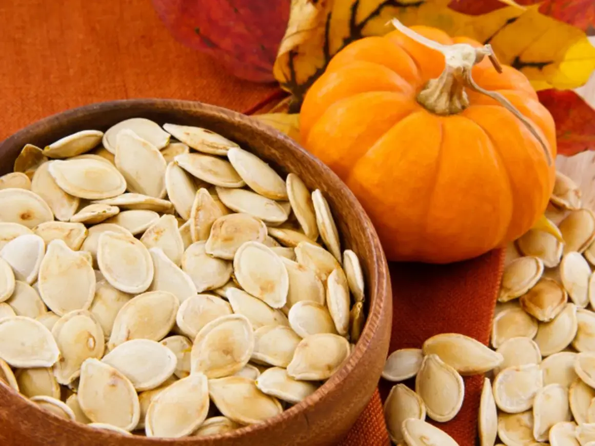 Dynia i miska pełna pestek dyni. Odkryj niezwykłe pestki dyni właściwości, które wzbogacą Twoją dietę.