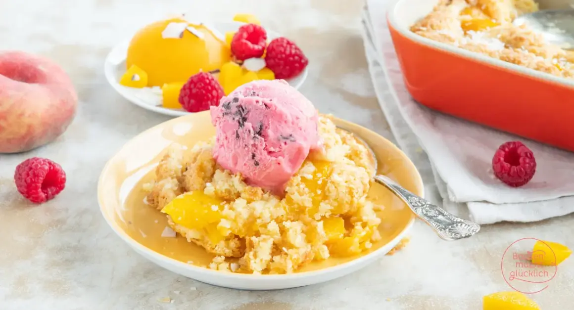 Ein warmer Pfirsich-Cobbler mit einer Kugel Himbeereis und frischen Himbeeren.