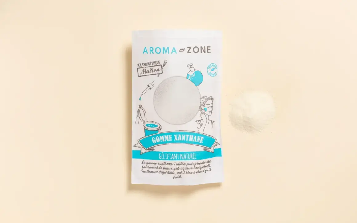 Un sachet de gomme xanthane Aroma-Zone, un gélifiant naturel pour vos cosmétiques maison. Une poudre fine à côté du paquet.