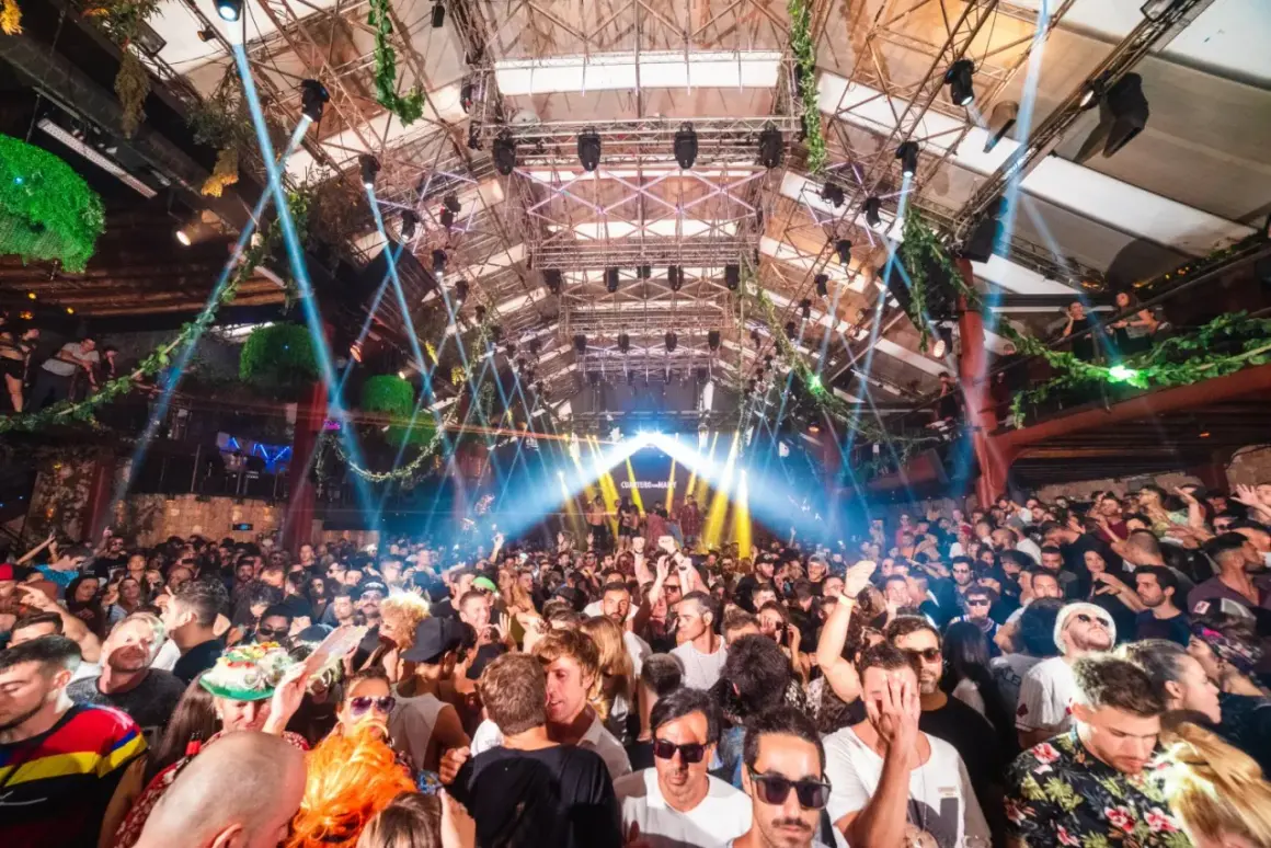 Folla scatenata ad Amnesia Ibiza, un evento indimenticabile con luci stroboscopiche e musica pulsante.