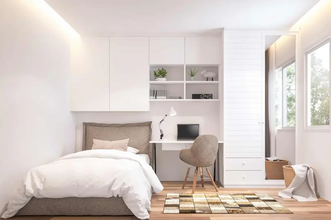 Ein modernes Schlafzimmer, das zum **Zimmer selber gestalten** einlädt. Ein Bett, Schreibtisch mit Laptop und ein Kleiderschrank mit Spiegel.