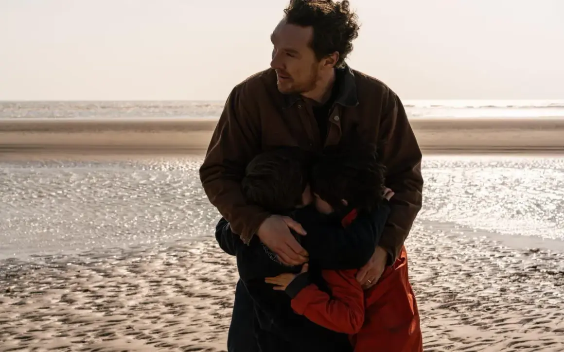 En man kramar sina barn på stranden. En scen som känns som en av de där comfort movies man vill se om och om igen.
