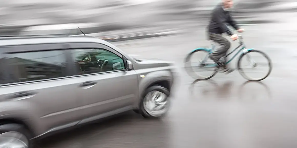 Een auto en fietser in beweging, mogelijk een situatie die leidt tot schadevergoeding fietsongeval.