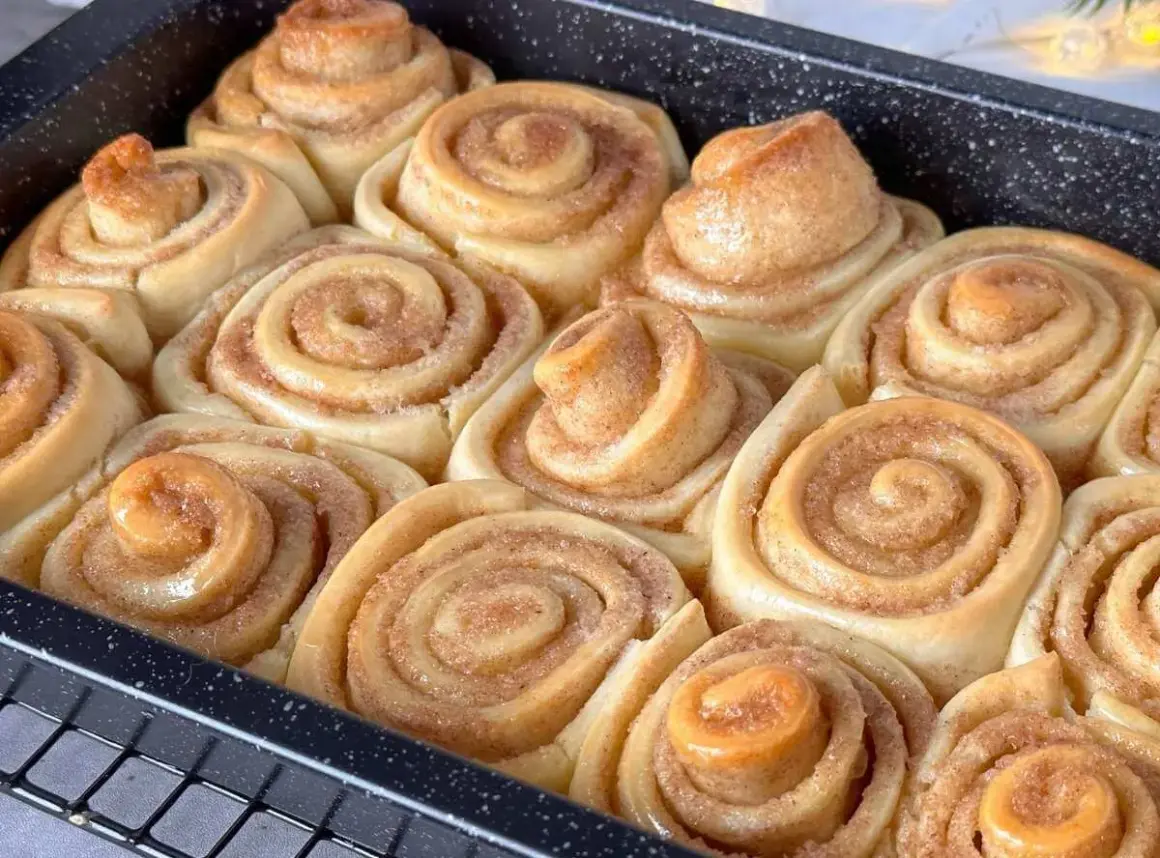 Frisch gebackene Zimtschnecken im Blech, bereit für das Zimtschnecken Rezept. Goldbraun und duftend, ein Genuss!