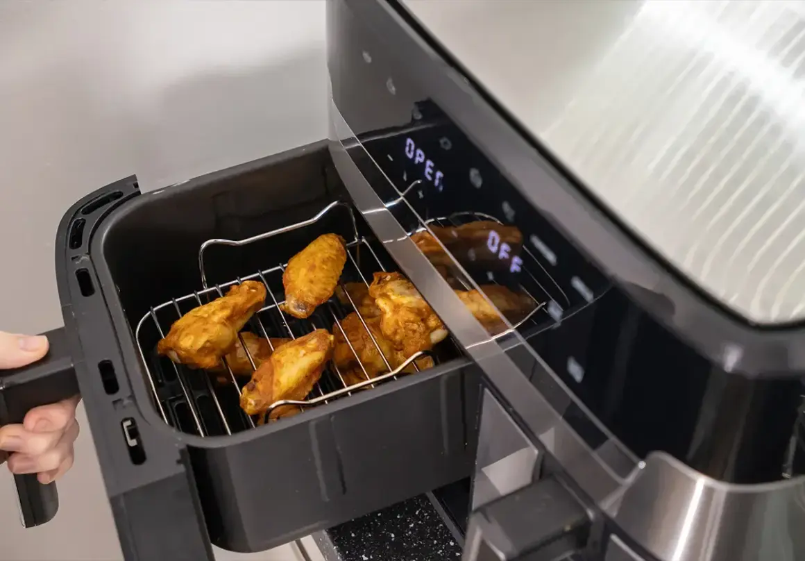 Złociste skrzydełka kurczaka w airfryerze, gotowe do podania. Pyszne dania z airfryer to szybki sposób na chrupiące przysmaki.