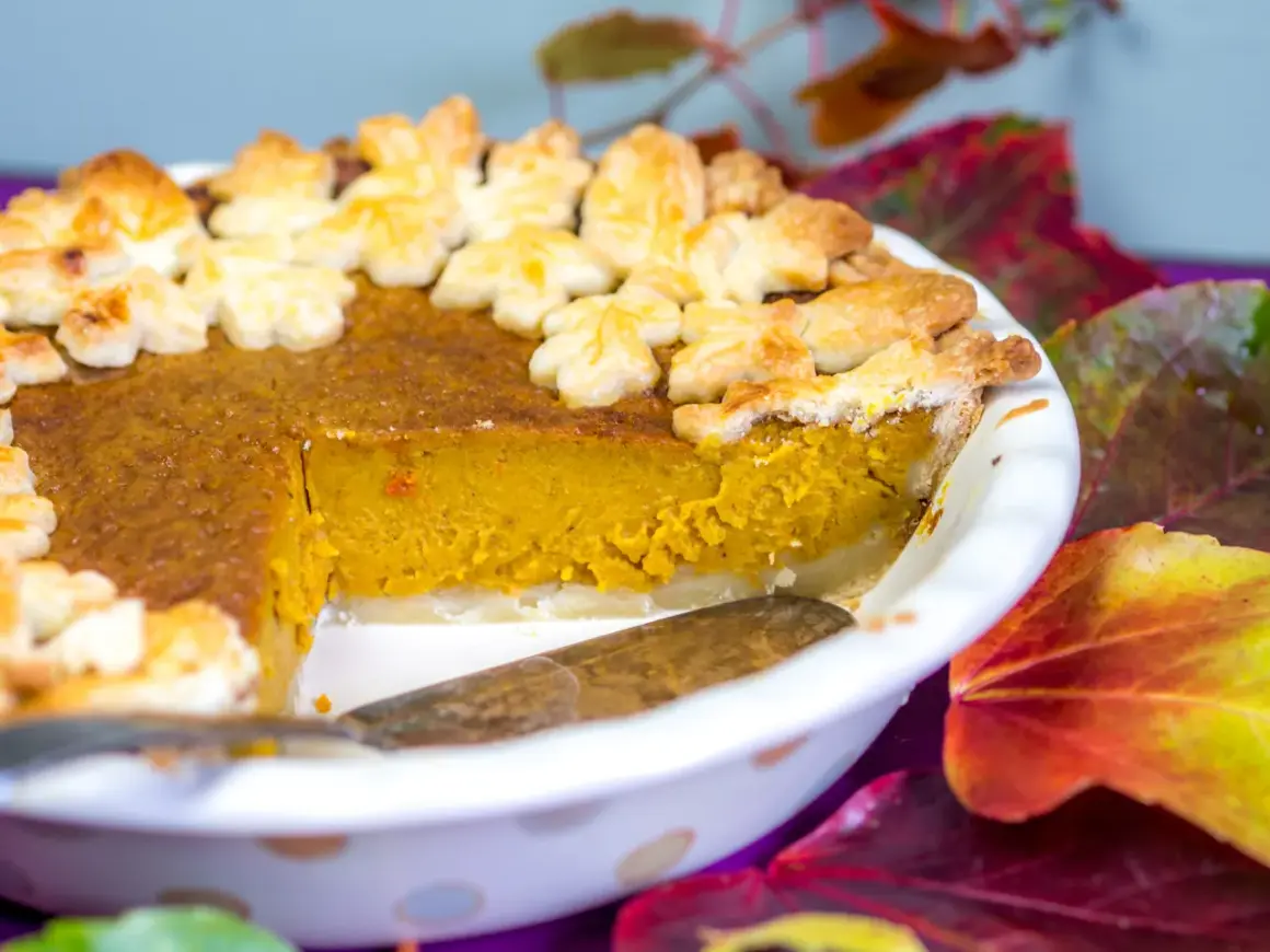 Ein leckerer Kürbiskuchen, dekoriert mit Blätter-Ausstechern, perfekt für Halloween.