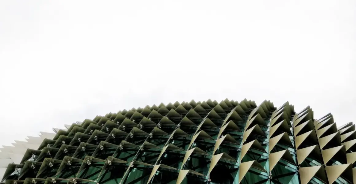 Edificio con facciata a squame triangolari, che ricorda i materiali a cambiamento di fase per la sua struttura dinamica e adattiva.