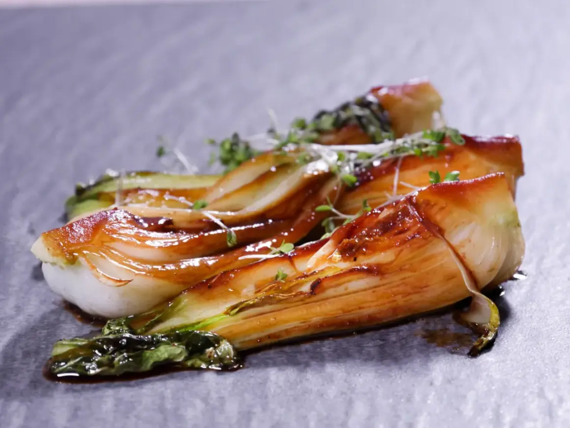 Gebratener Pak Choi mit glänzender Glasur, garniert mit frischen Kräutern. Ein köstliches Pak Choi Rezept, das Lust auf mehr macht.