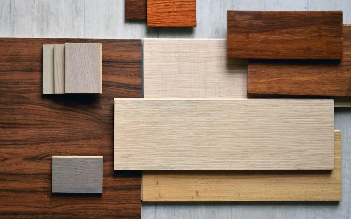 Campione di diversi tipi di parquet in varie tonalità di legno, dal chiaro al scuro, con venature visibili.