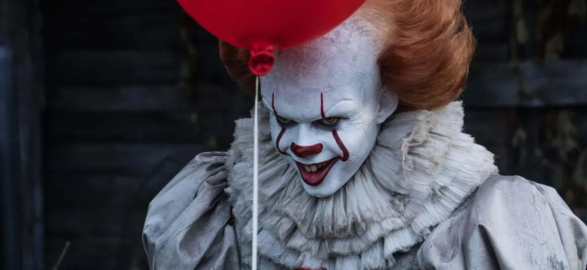 Przerażający klaun Pennywise, znany ze slasherów, trzyma czerwony balon.