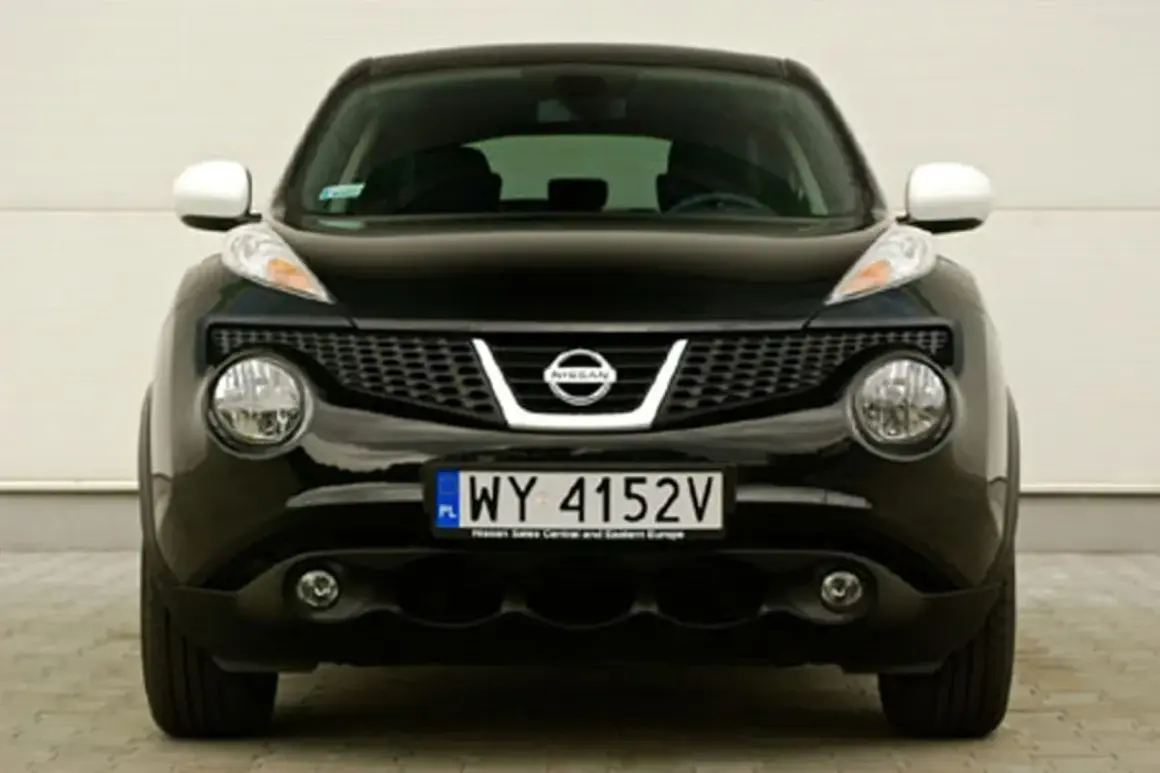 Czarny Nissan Juke 1.6 benzyna z charakterystycznymi okrągłymi światłami i kratką.
