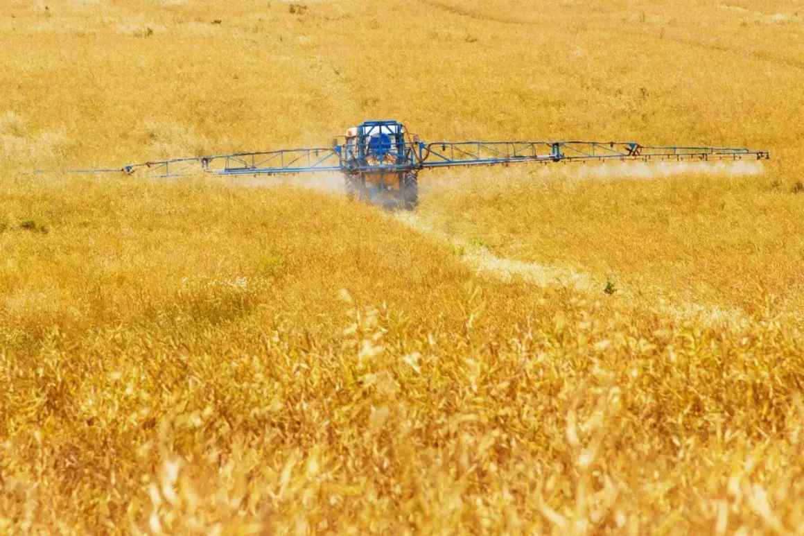 Trattore spruzza pesticidi su un campo dorato, contribuendo all'inquinamento agricolo.