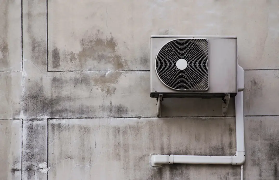 Unité extérieure d'une pompe à chaleur installée sur un mur en béton. Le système est prêt à fonctionner.