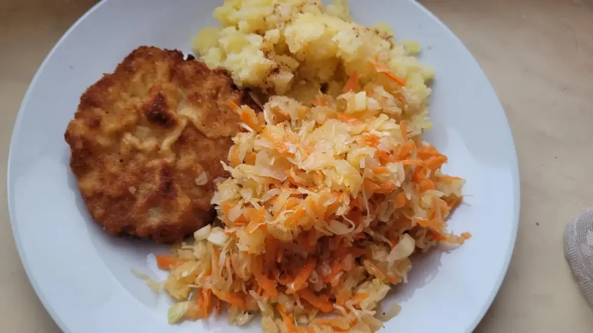 Złocisty kotlet schabowy z ziemniakami i surówką z kapusty i marchewki – idealne połączenie, co pasuje do schabowego.