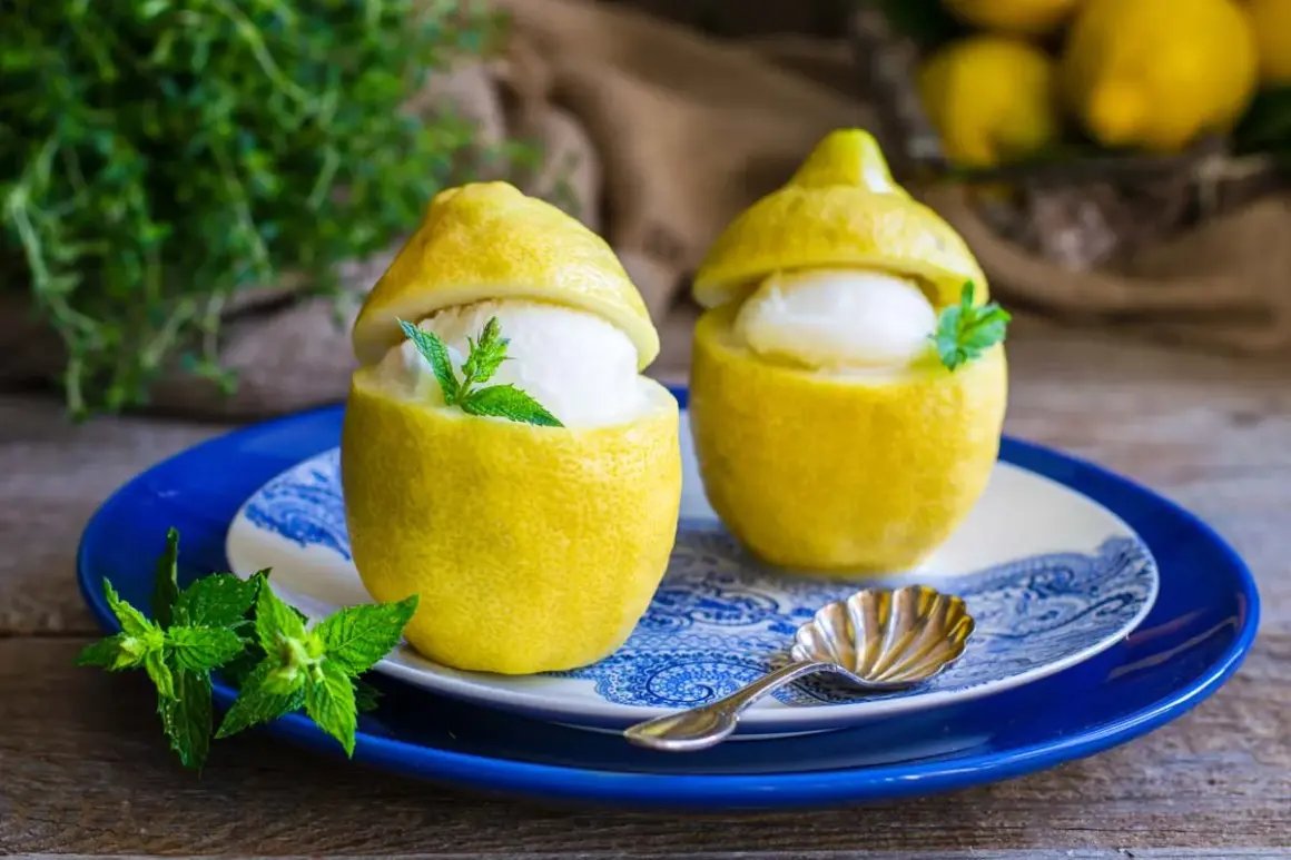 Delizioso gelato al limone servito in limoni svuotati, guarnito con menta fresca. Un'idea rinfrescante preparata con una gelatiera.