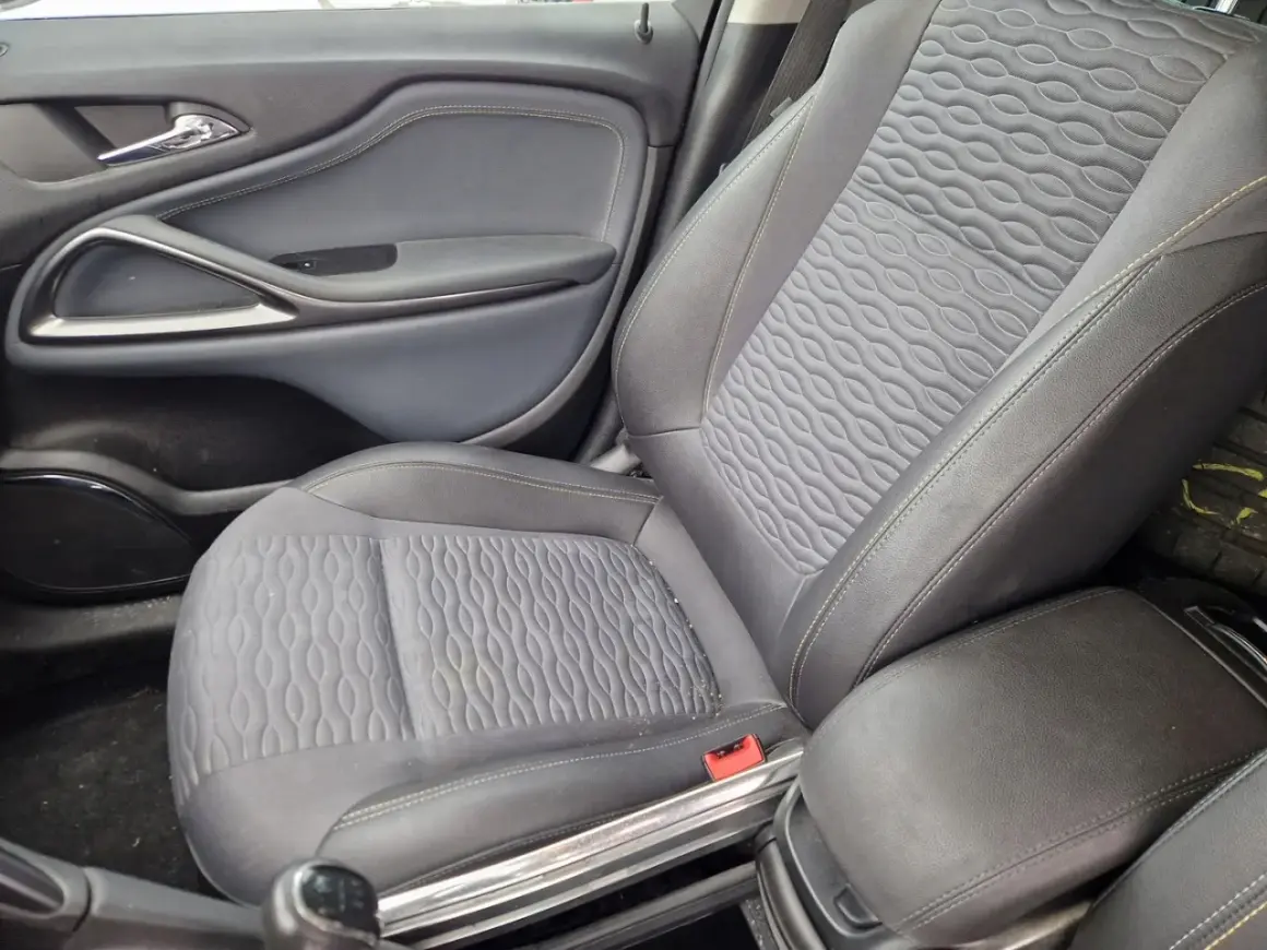 Wnętrze samochodu Opel Astra J: siedzenie z tapicerką i panel drzwi.
