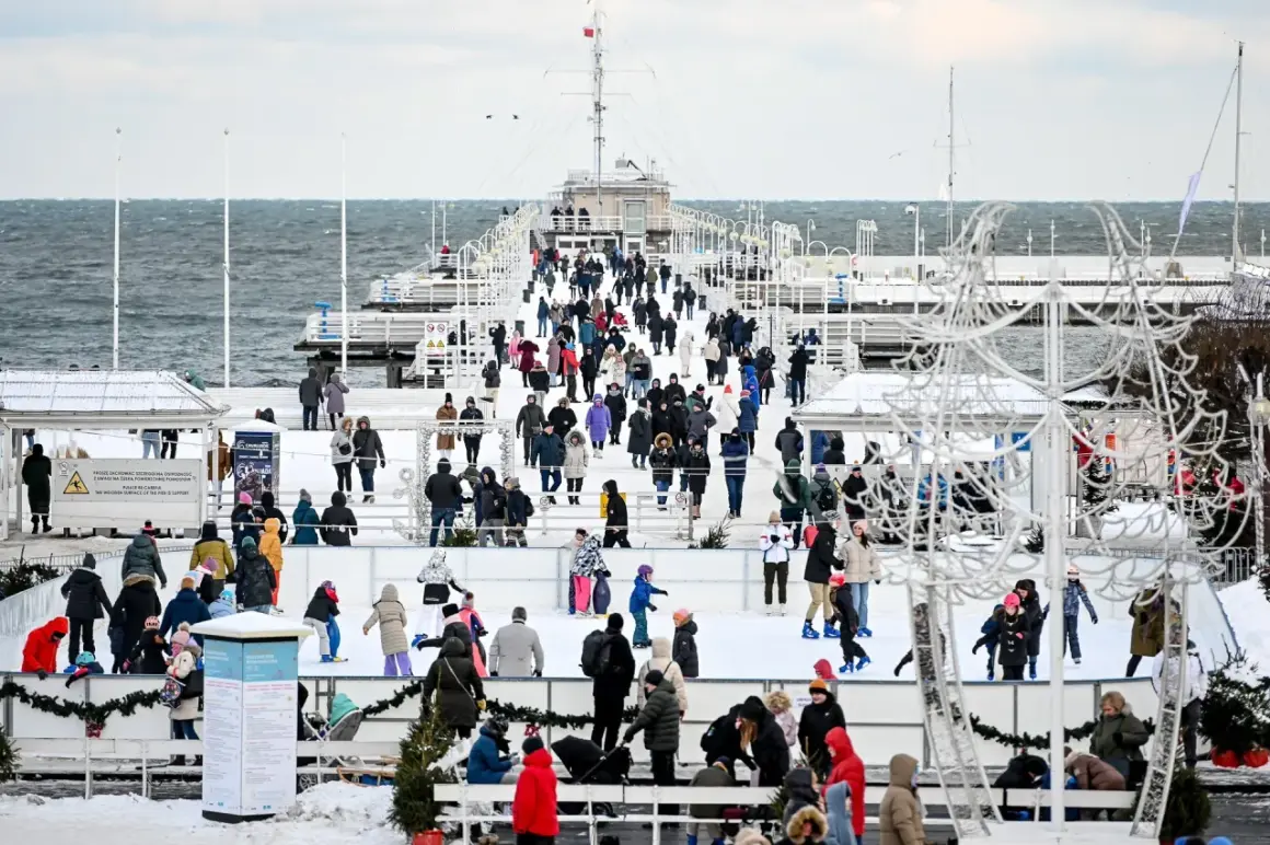 Sopot atrakcje zimą: lodowisko na molo, tłumy ludzi w ciepłych ubraniach, morze w tle.